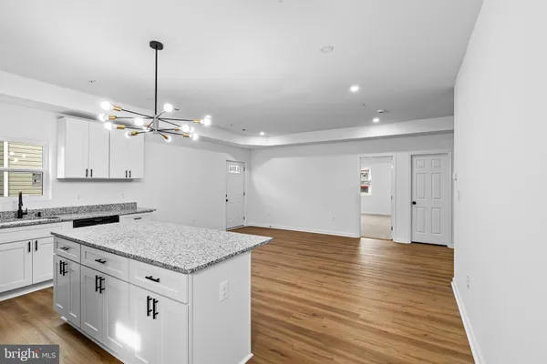 a kitchen with stainless steel appliances granite countertop a sink a stove and a wooden floors