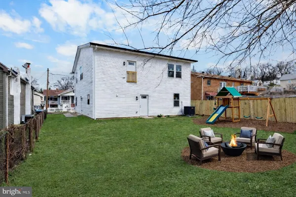 a view of a backyard with couches chair and fire pit