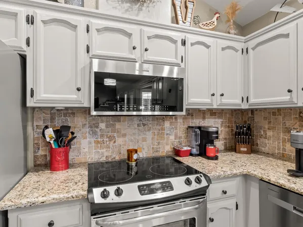 a kitchen with stainless steel appliances granite countertop a sink and cabinets