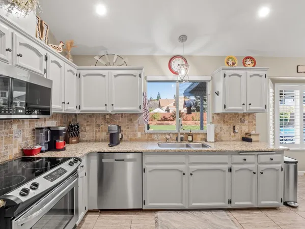 a kitchen with white cabinets and appliances