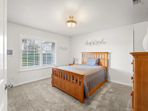 a bed sitting in a bedroom next to a window