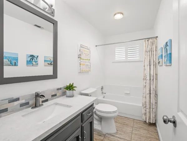 a bathroom with a granite countertop sink a toilet and a mirror