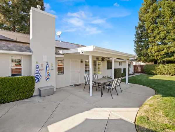 a view of a patio with table and chairs near a yard