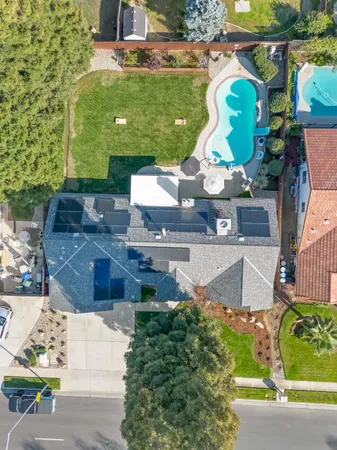 an aerial view of a house with a garden and pool