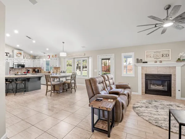 a living room with furniture a fireplace and a kitchen view