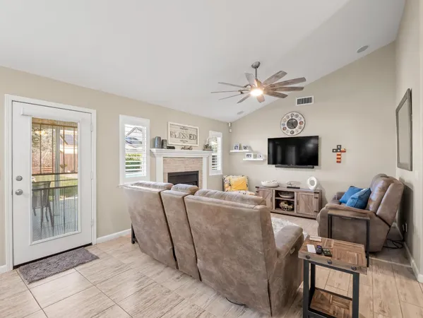 a living room with furniture a flat screen tv and a fireplace