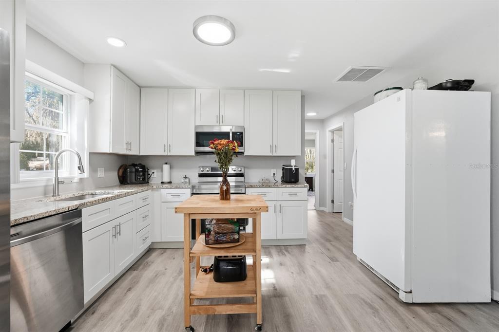 270 Wright Grove Road Oak Hill, FL 32759 - Photo 9 of 17 a kitchen with white cabinets and white appliances