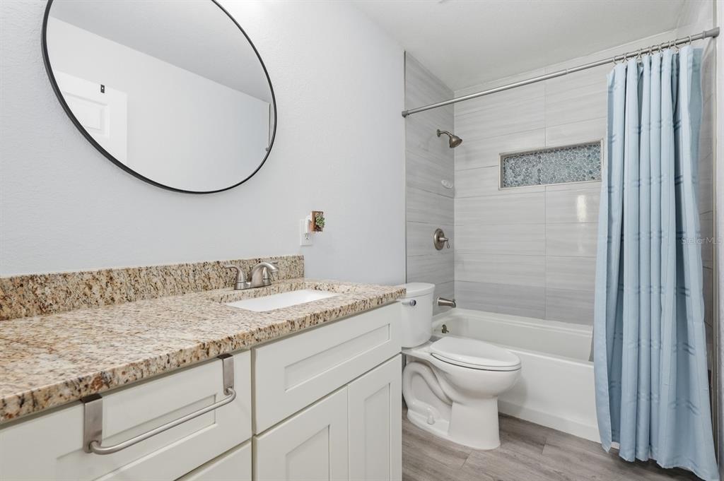 270 Wright Grove Road Oak Hill, FL 32759 - Photo 10 of 17 a bathroom with a granite countertop sink a toilet and a mirror