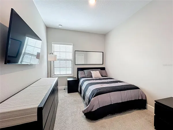 a bedroom with a bed and a flat screen tv