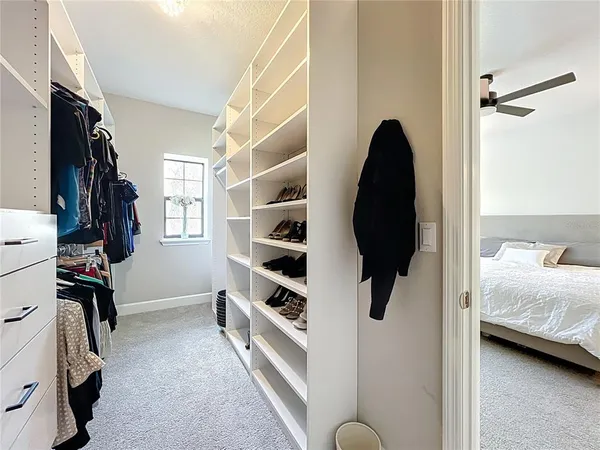 a view of walk in closet with clothes and shoes
