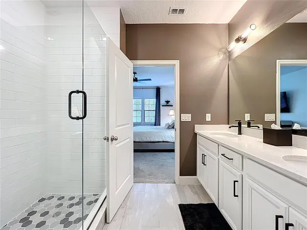a en suite bathroom with a granite countertop sink and a mirror