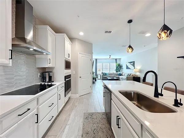 a open kitchen with stainless steel appliances granite countertop a sink a stove and a refrigerator