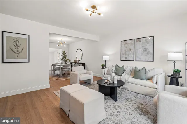 a living room with furniture a table and wooden floor