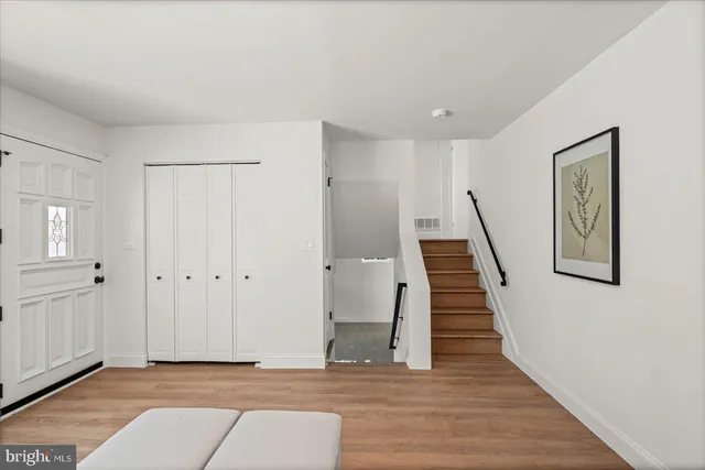 a view of a hallway with wooden floor and staircase