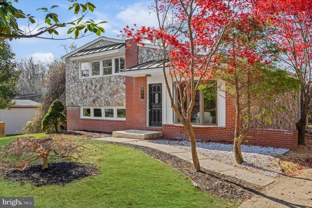 a front view of a house with a yard and wooden fence