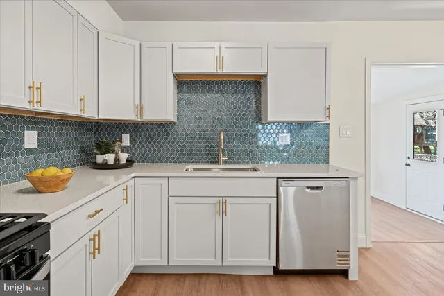 a kitchen with stainless steel appliances kitchen island granite countertop a kitchen island hardwood floor and a sink