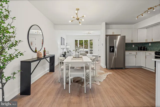 a view of a dining room with furniture a chandelier and wooden floor