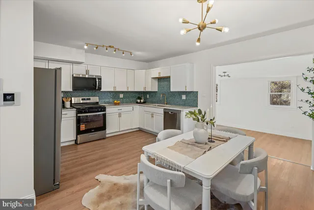 a kitchen with kitchen island a stove a table and chairs in it