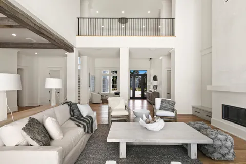 a view of a hallway with wooden floor and a bathroom