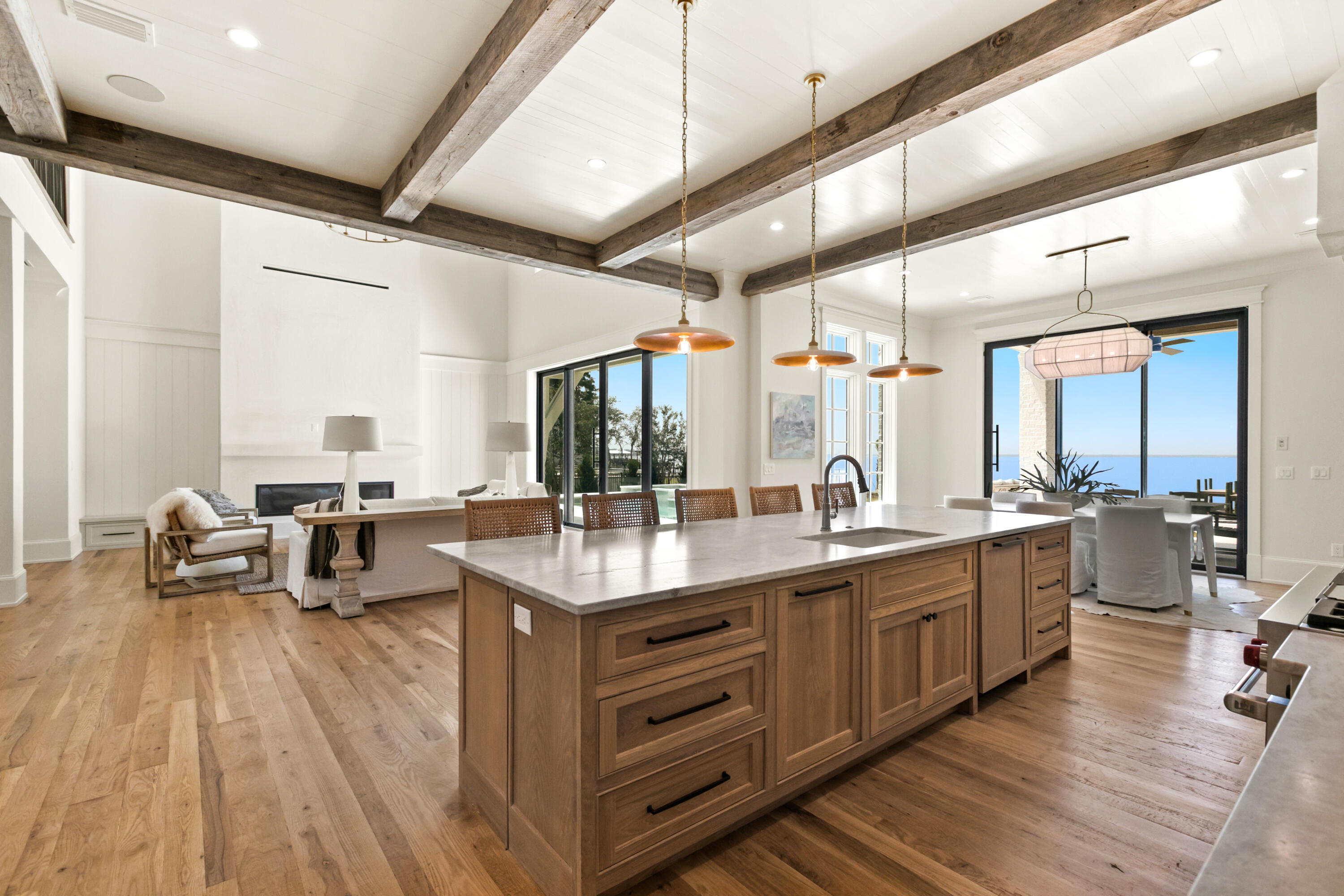 22 Carolyn Lane Santa Rosa Beach, FL 32459 - Photo 36 of 108 a large kitchen with kitchen island a sink dishwasher a dining table and chairs with wooden floor