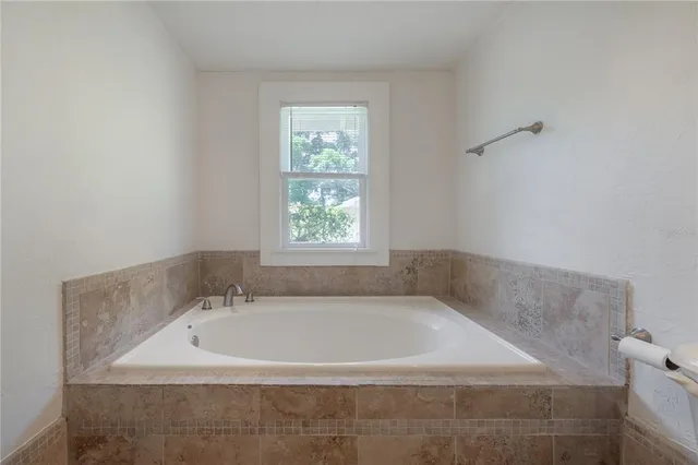 a white bath tub sitting in a bathroom next to a window