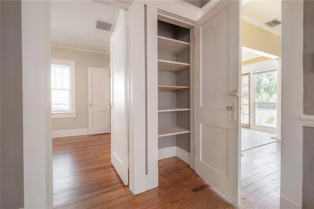 a view of a hallway with wooden floor and closet