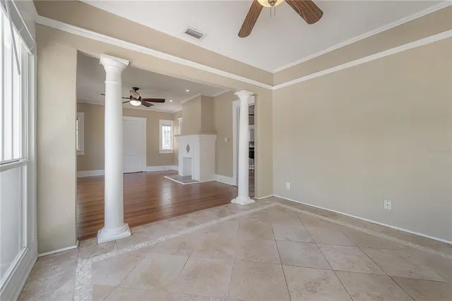 an empty room with ceiling fan and bathroom view
