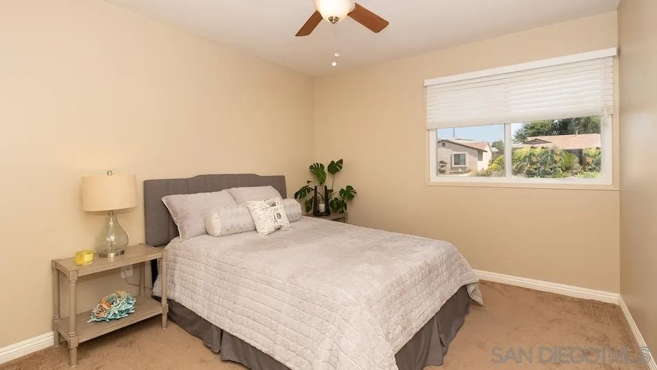 9265 Ruffin Road Santee, CA 92071 - Photo 14 of 25 a bedroom with a bed and a chandelier