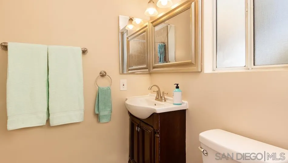 9265 Ruffin Road Santee, CA 92071 - Photo 16 of 25 a bathroom with a sink a toilet and mirror