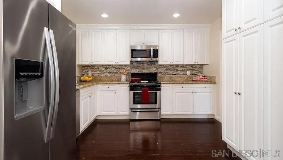 9265 Ruffin Road Santee, CA 92071 - Photo 9 of 25 a kitchen with stainless steel appliances a refrigerator stove and microwave