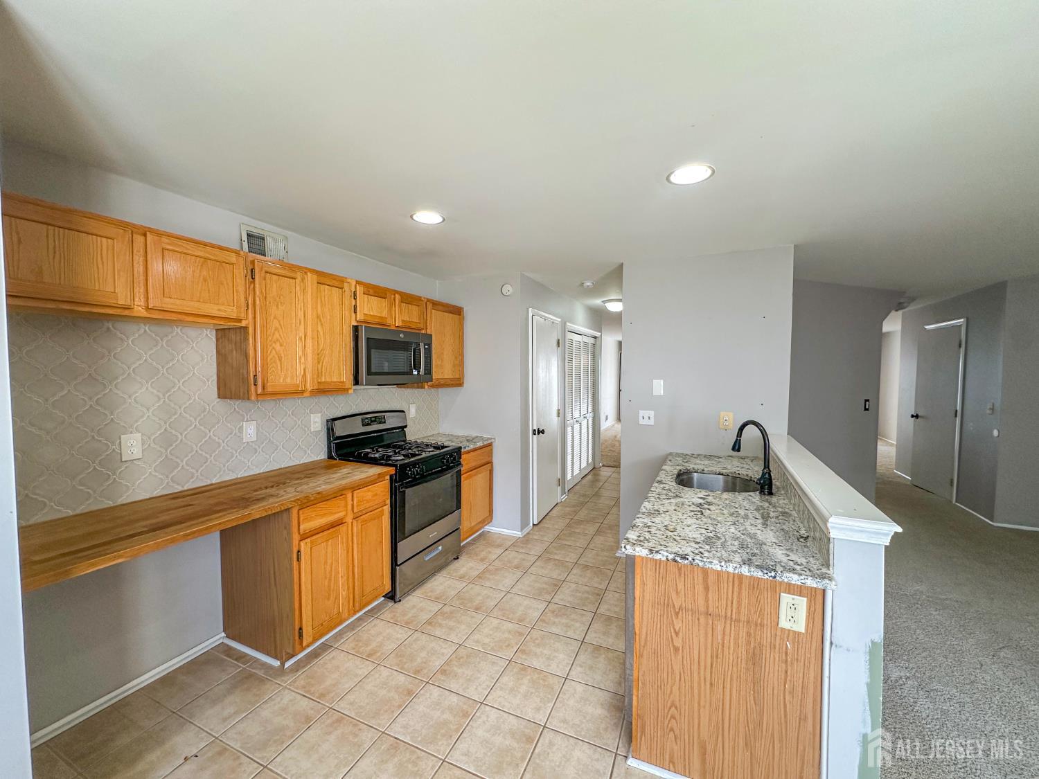 1212 Plymouth Road North Brunswick, NJ 08902 - Photo 11 of 27 a kitchen with stainless steel appliances granite countertop a sink stove and refrigerator