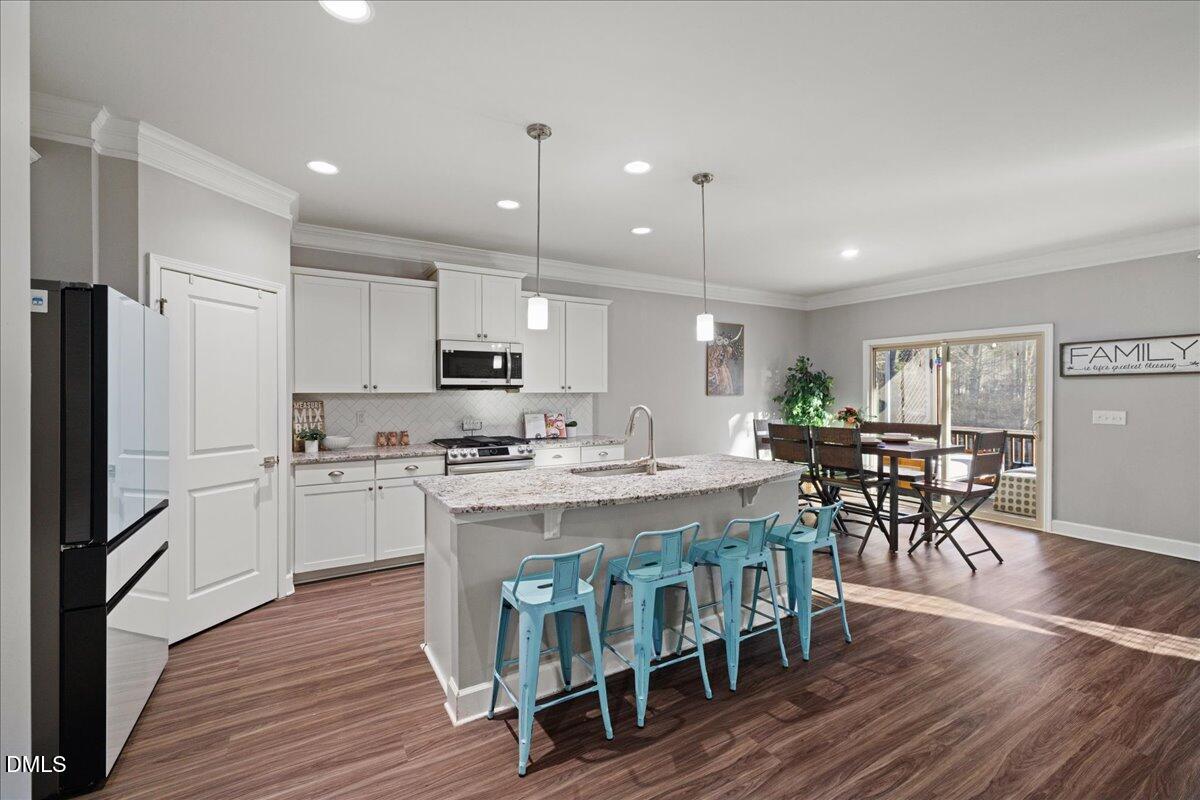 7804 Charters End Street Willow Spring, NC 27592 - Photo 5 of 43 a large kitchen with kitchen island a dining table and chairs