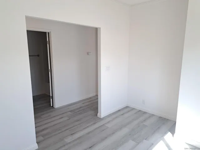 an empty room with wooden floor and closet