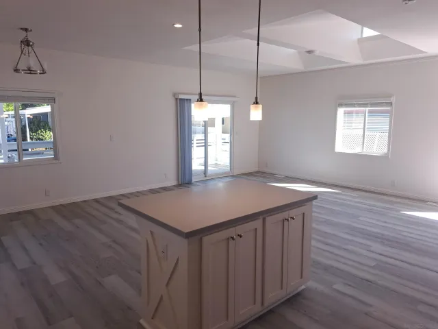 a kitchen with a wooden floor and a chandelier