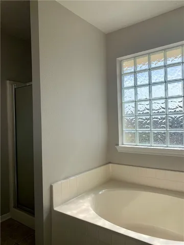 a white bath tub sitting in a bathroom next to a window