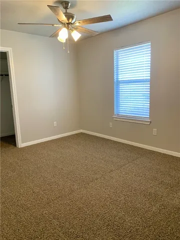 an empty room with a window and a fan