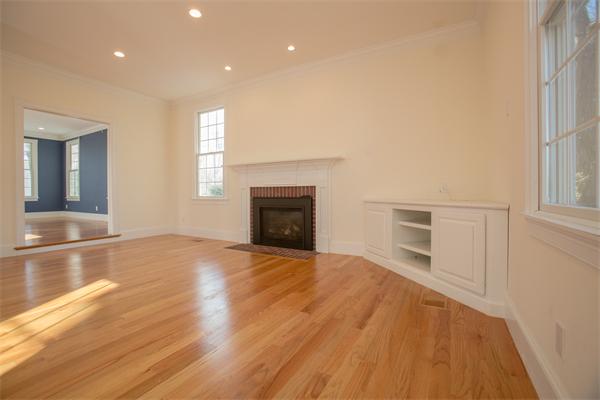 65 Ivy Road Wellesley, MA 02482 - Photo 3 of 9 an empty room with wooden floor fireplace and windows