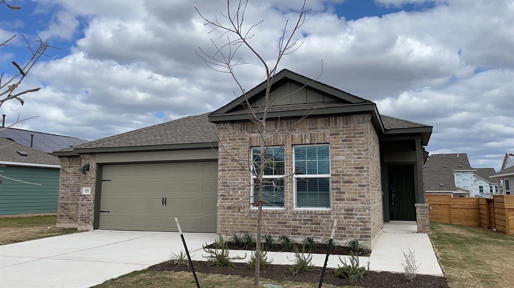 125 Madrid Kyle, TX 78640 - Photo 2 of 23 View of front of home featuring an attached garage, driveway, brick siding, and a shingled roof