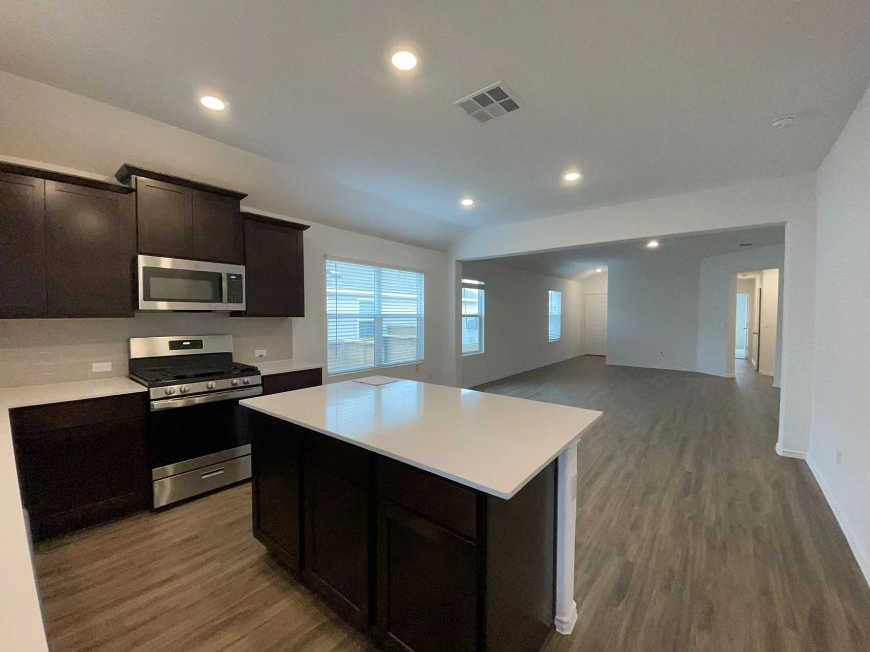 125 Madrid Kyle, TX 78640 - Photo 23 of 23 Kitchen featuring stainless steel appliances, dark wood-type flooring, open floor plan, a kitchen island, and vaulted ceiling