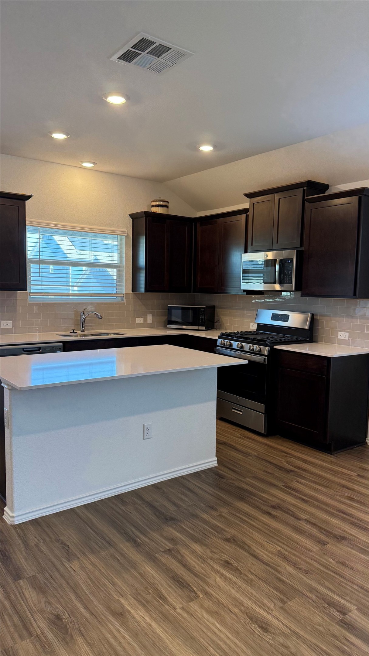 125 Madrid Kyle, TX 78640 - Photo 4 of 23 Kitchen featuring tasteful backsplash, dark wood finish cabinets, and recessed lighting