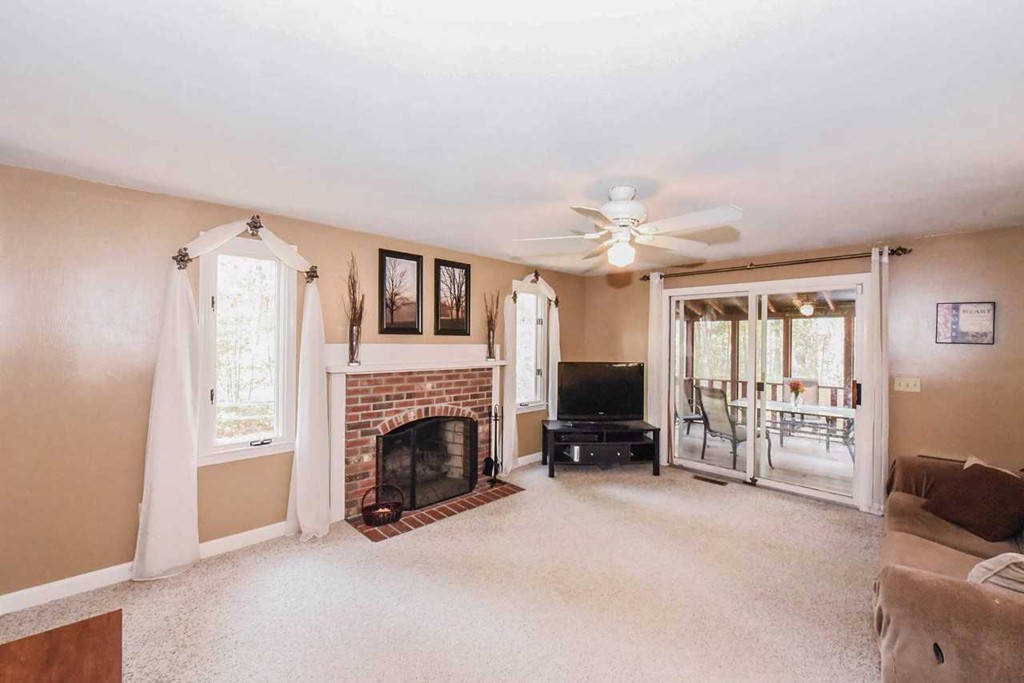 4 Nehemiah Road Shirley, MA 01464 - Photo 5 of 25 a view of a livingroom with a fireplace and a ceiling fan