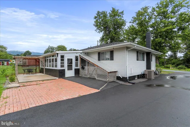 a white house with a large tree and wooden fence