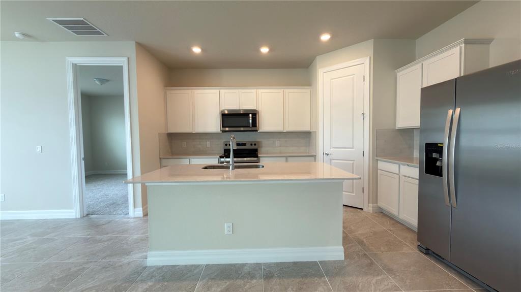 1523 Groveline Road St. Cloud, FL 34771 - Photo 12 of 30 a kitchen with kitchen island stainless steel appliances cabinets a sink and a counter top space