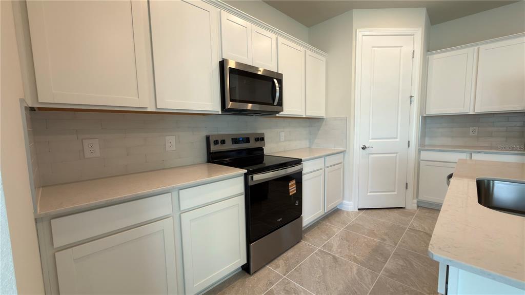 1523 Groveline Road St. Cloud, FL 34771 - Photo 13 of 30 a kitchen with a sink and a stove top oven