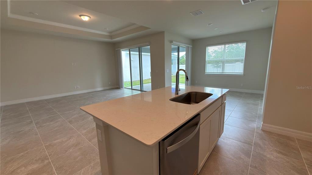 1523 Groveline Road St. Cloud, FL 34771 - Photo 14 of 30 a kitchen with a sink a counter top and a refrigerator