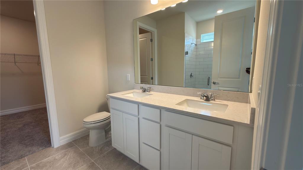 1523 Groveline Road St. Cloud, FL 34771 - Photo 18 of 30 a bathroom with a toilet a sink and mirror