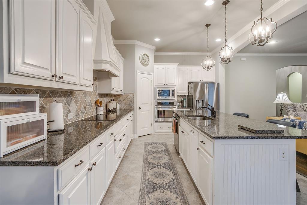 329 Madison Street Burleson, TX 76028 - Photo 13 of 40 a large kitchen with granite countertop lots of counter space and stainless steel appliances