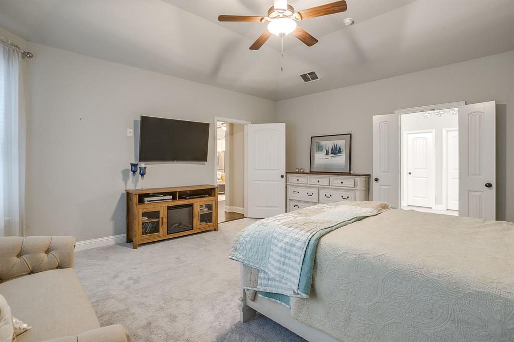 329 Madison Street Burleson, TX 76028 - Photo 18 of 40 a spacious bedroom with a bed and a flat screen tv