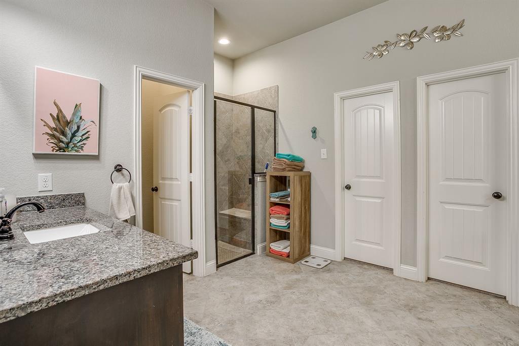 329 Madison Street Burleson, TX 76028 - Photo 19 of 40 a bathroom with a granite countertop sink a mirror and a shower