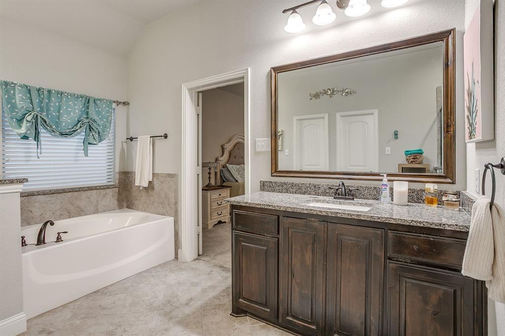 329 Madison Street Burleson, TX 76028 - Photo 22 of 40 a bathroom with a tub a double vanity sink and mirror